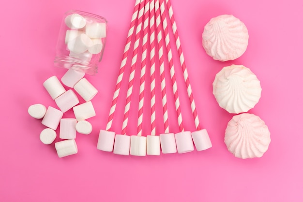 Weiße Marshmallows der Draufsicht mit Baisers auf rosa Schreibtisch, zuckersüße Farbe