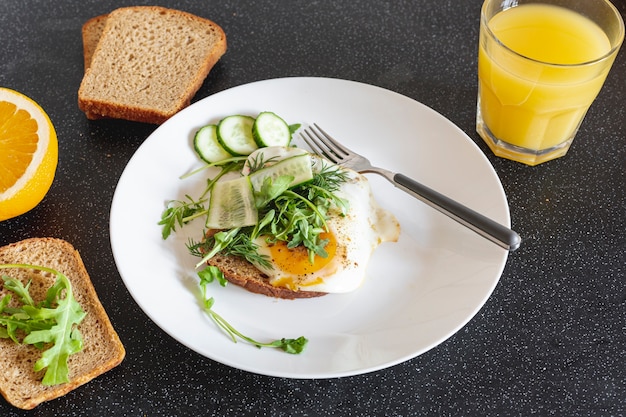 Weiße Platte mit Spiegeleiern und Orangensaft