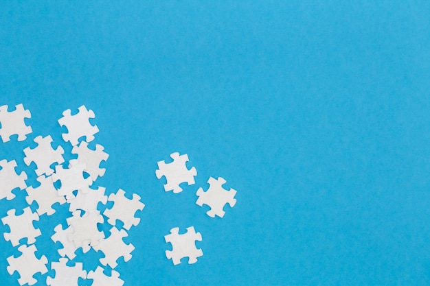 Kostenloses Foto weiße puzzles auf blauem hintergrund liegen flach