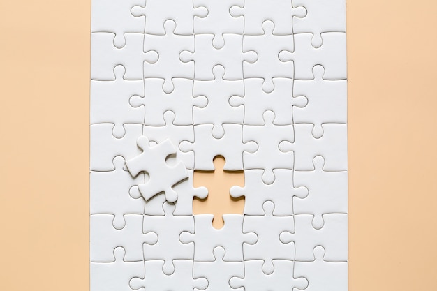 weiße Puzzlestücke auf Rosa