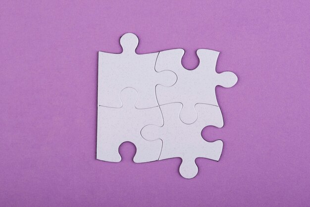 Weiße Puzzleteile der Draufsicht und purpurroter Hintergrund