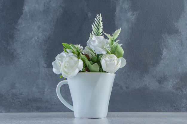 Weiße Rosen in einer weißen Tasse auf weißem Hintergrund. Foto in hoher Qualität