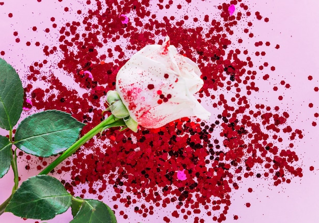 Weiße Rosenzweig mit Flitter auf rosa Tabelle