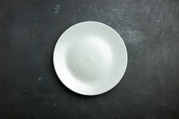 Weiße runde Platte der Draufsicht auf dunklem Tisch mit Kopierplatz