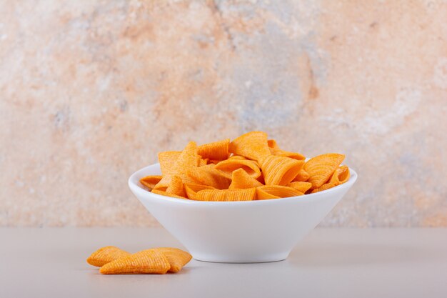 Weiße Schüssel der Dreieckschips auf Marmorhintergrund. Hochwertiges Foto