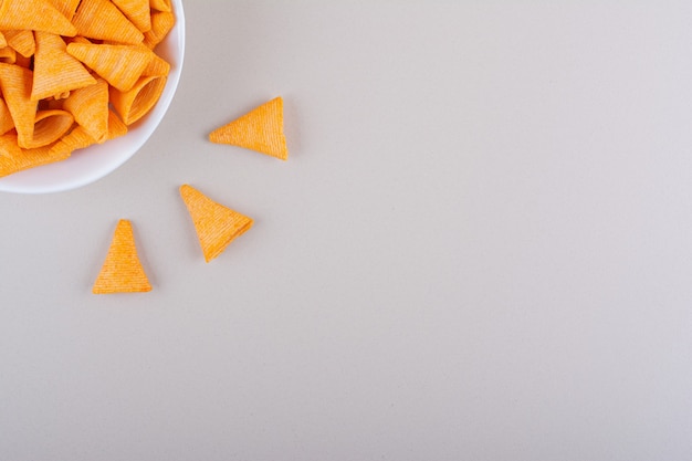 Weiße Schüssel mit Dreieckschips auf Marmorhintergrund. Foto in hoher Qualität