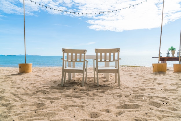 Weiße Stühle und Tisch am Strand