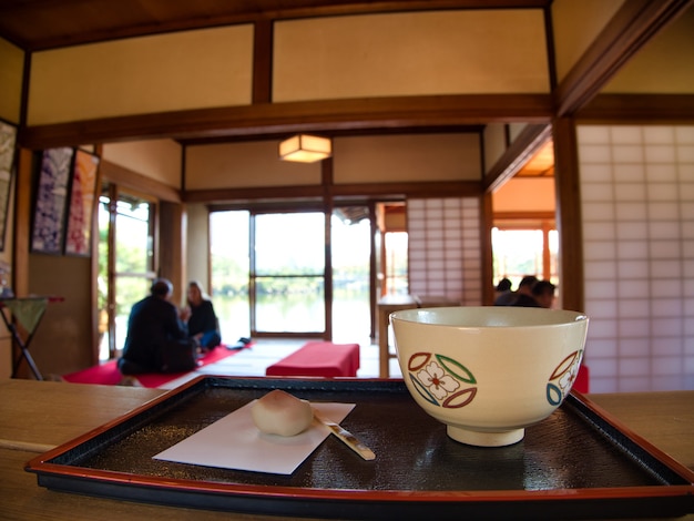 Kostenloses Foto weiße tasse mit mustern auf einem schwarzen tablett in einem restaurant