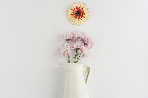 Weiße Vase mit Blumen in lila Tönen