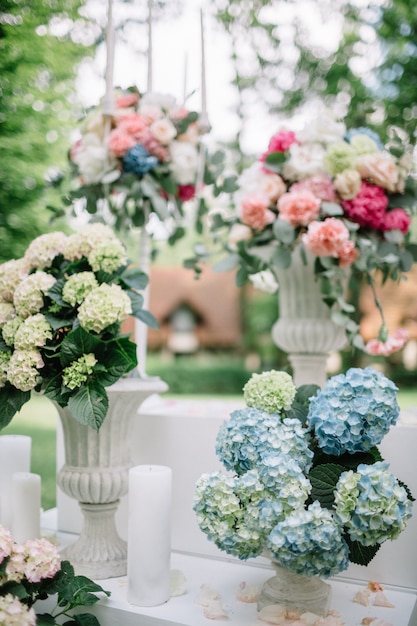 Weiße Vasen mit Blumen stehen draußen