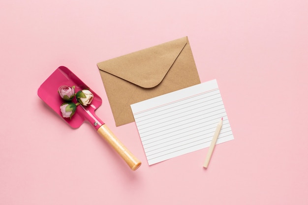 Weißer Buchstabe und Schaufel mit Blumen