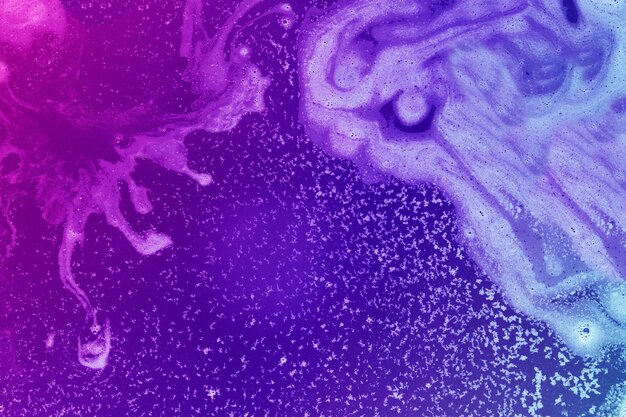 Weißer Farbstoff in violettem und magentarotem Wasser