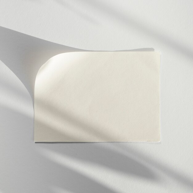 Weißer Hintergrund mit einem weißen Blatt Papier mit seinem Schatten