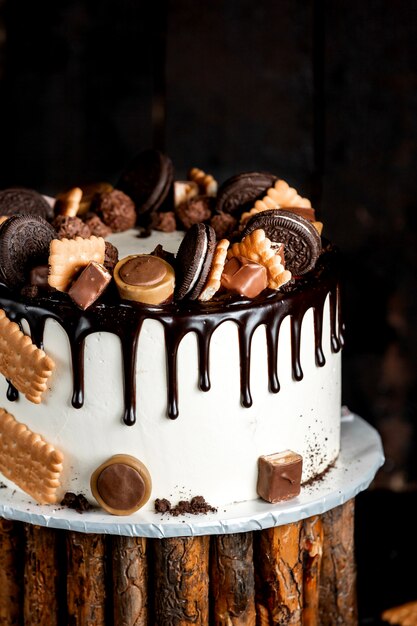 Weißer Kuchen mit Schokolade gegossen und mit Oreo- und Tofifi-Keksen dekoriert