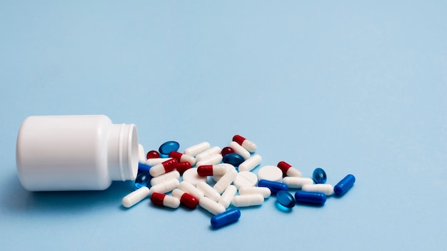Weißer Pillenbehälter auf blauem Hintergrund