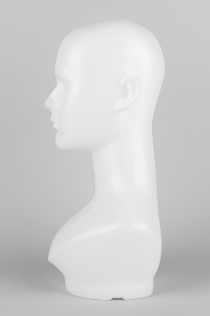 Weißer Schaufensterpuppenkopf im Profil auf grauem Hintergrund
