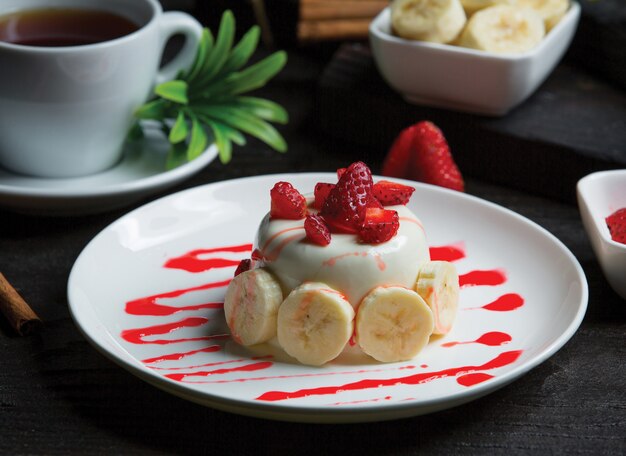 Weißer Schokoladenkleiner kuchen mit Bananen und Erdbeeren