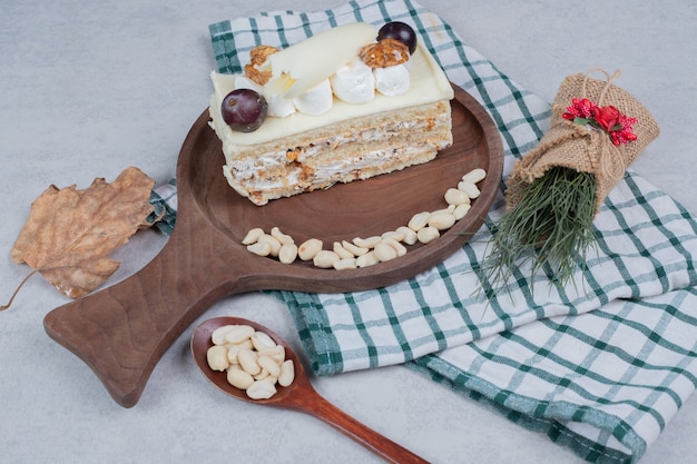 Kostenloses Foto weißer schokoladenkuchen auf holzbrett mit weihnachtsdekorationen. hochwertiges foto