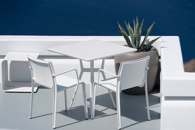 Weißer Tisch und Stühle auf der Terrasse in Oia, Santorini.