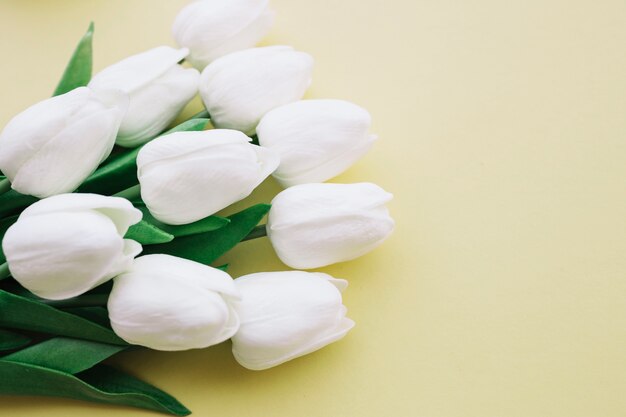 weißer Tulpenblumenstrauß auf gelbem Hintergrund