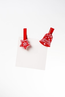 Weißer zettel mit roter weihnachtswäscheklammer. platz kopieren