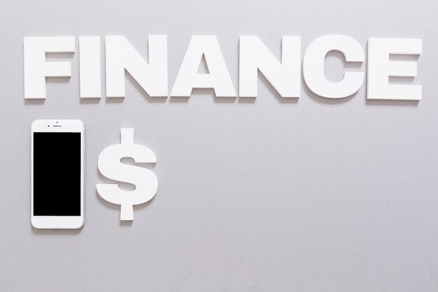 Weißes Finanzwort mit Dollarzeichen und Smartphone auf grauem Hintergrund