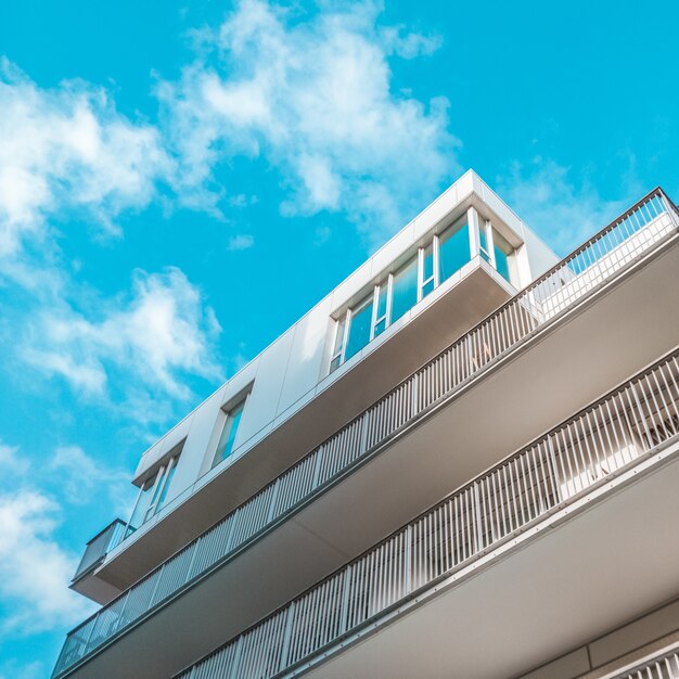 Weißes Gebäude mit Balkonen und blauem Himmel