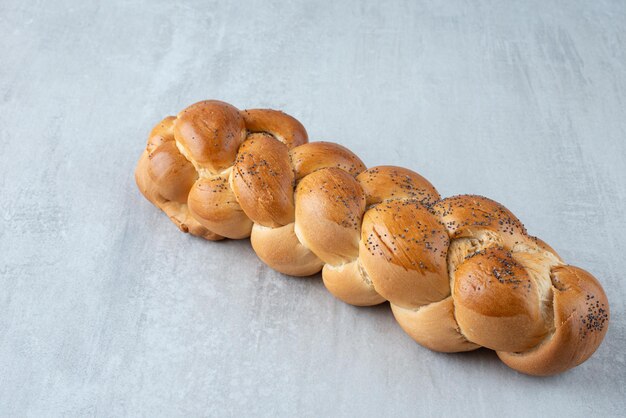 Weißes geflochtenes Brot auf Steintisch.