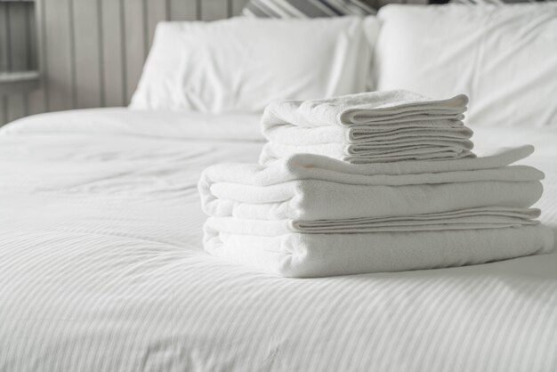 Weißes Handtuch auf Bettdekoration im Schlafzimmer Interieur