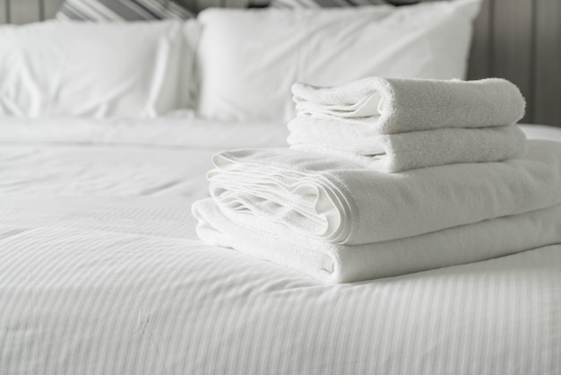 Weißes Handtuch auf Bettdekoration im Schlafzimmer Interieur