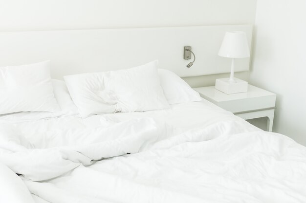 Weißes Kissen auf zerknittertem Bett