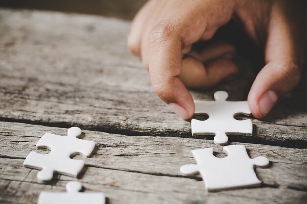 Weißes Puzzle auf einem Holztisch