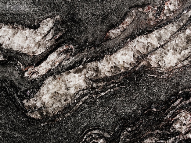 Weißes raues strukturiertes auf schwarzem Felsenhintergrund