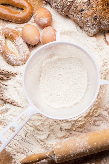 Weißes Sieb mit Mehl und Brot