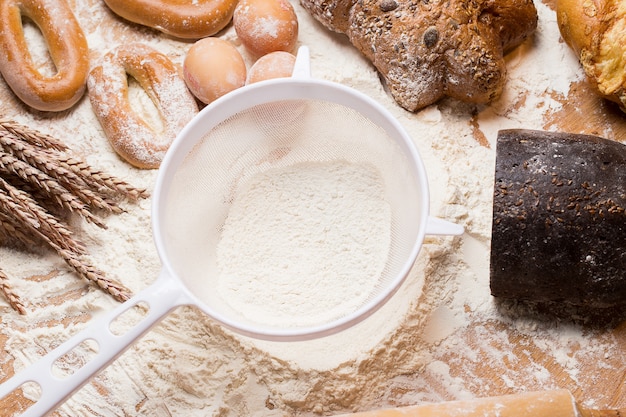 Weißes Sieb mit Mehl und Brot