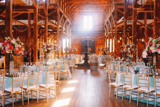 Weißes Tageslicht erhellt einen hölzernen Hangar, der für eine Hochzeit vorbereitet wird