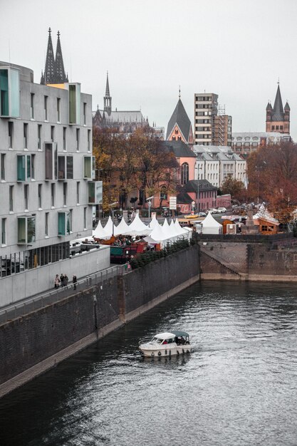 Weißes und schwarzes Boot auf Fluss nahe Betongebäude