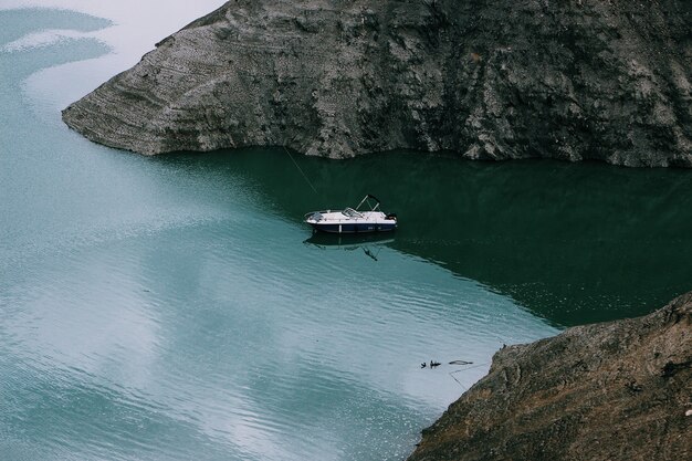 Weitwinkelaufnahme eines Motorboots auf dem Gewässer mitten in den Bergen