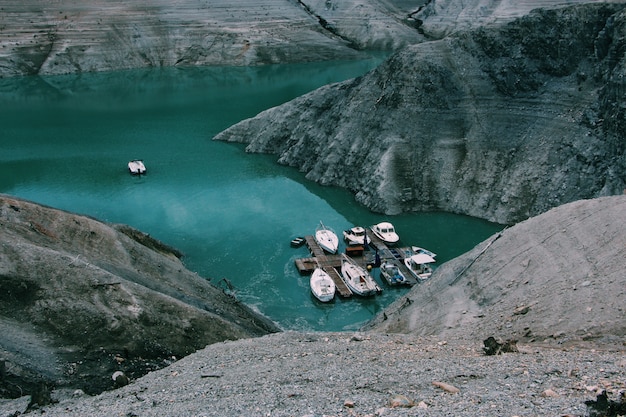 Kostenloses Foto weitwinkelaufnahme von booten auf dem gewässer, umgeben von bergen