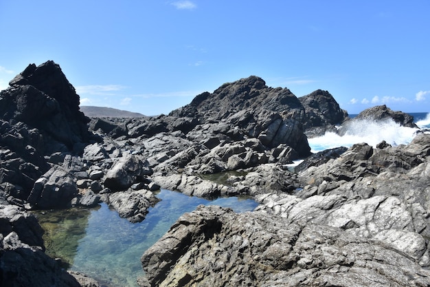 Wellen, die um einen geheimen, versteckten natürlichen Pool in Aruba kaskadieren