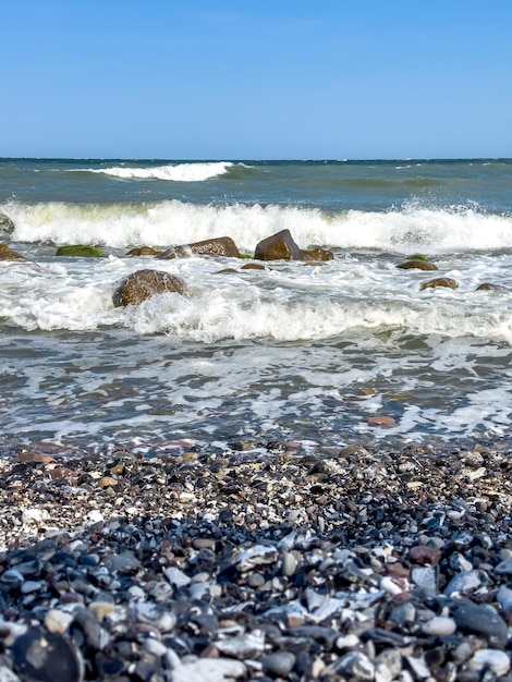 Wellen im Meer in der Nähe der Küste an einem leeren Kiesstrand