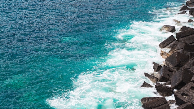 Wellenförmiges Wasser der Nahaufnahme an der felsigen Küste