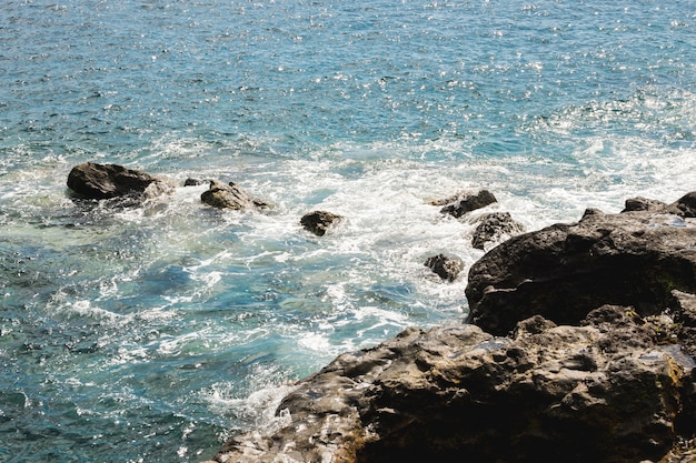 Wellenförmiges Wasser der oben genannten Ansicht am felsigen Ufer