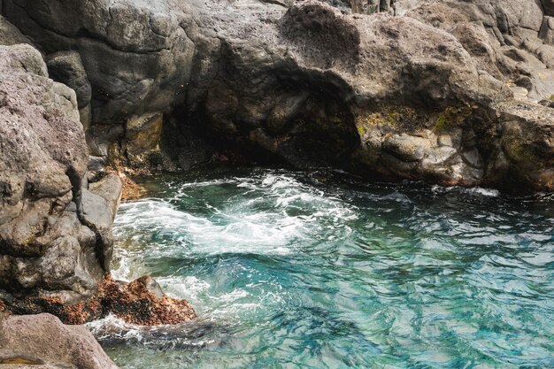 Wellenförmiges Wasser der oben genannten Ansichtnahaufnahme am felsigen Ufer