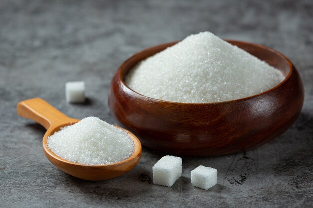 Weltdiabetestag; Zucker in Holzschale auf dunkler Oberfläche