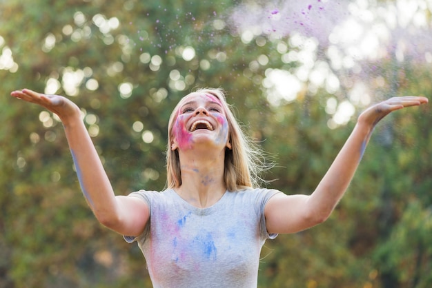 Kostenloses Foto werfende farbe der glücklichen frau in der luft