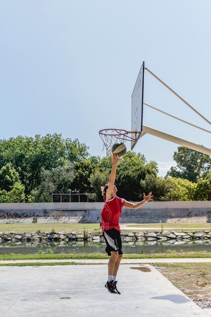 Werfender Ball des Basketball-Spielers im Band am Freiengericht