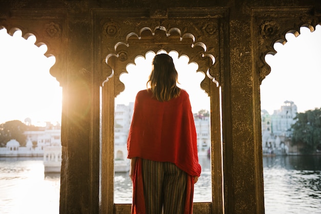 Kostenloses Foto westfrau, die auf einer kulturarchitektur in udaipur, indien steht