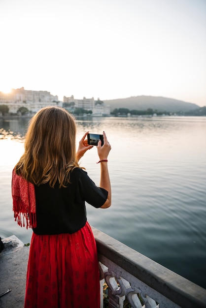 Westfrau, welche die Ansicht von Udaipur-Stadt, Indien gefangennimmt