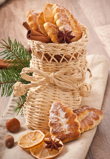 Wicker Weihnachtsstrumpf gefüllt mit Keksen, Zimtstangen, kandierter Zitrone und Sternanis